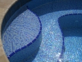 Glass-tile spa with baja steps and beach entry — custom pool by True Blue Pools