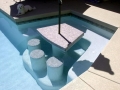 Homepage Features 8 — in-pool seating with umbrella shade on a custom pool by True Blue Pools