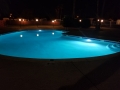 Custom pool lit up at night with colorful LED pool lighting by True Blue Pools (5)