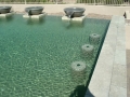 Custom pool with fountain water feature and in-pool table seating remodel by True Blue Pools