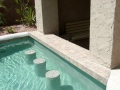 Custom Mesa pool with built-in bar seating, table and stools by True Blue Pools